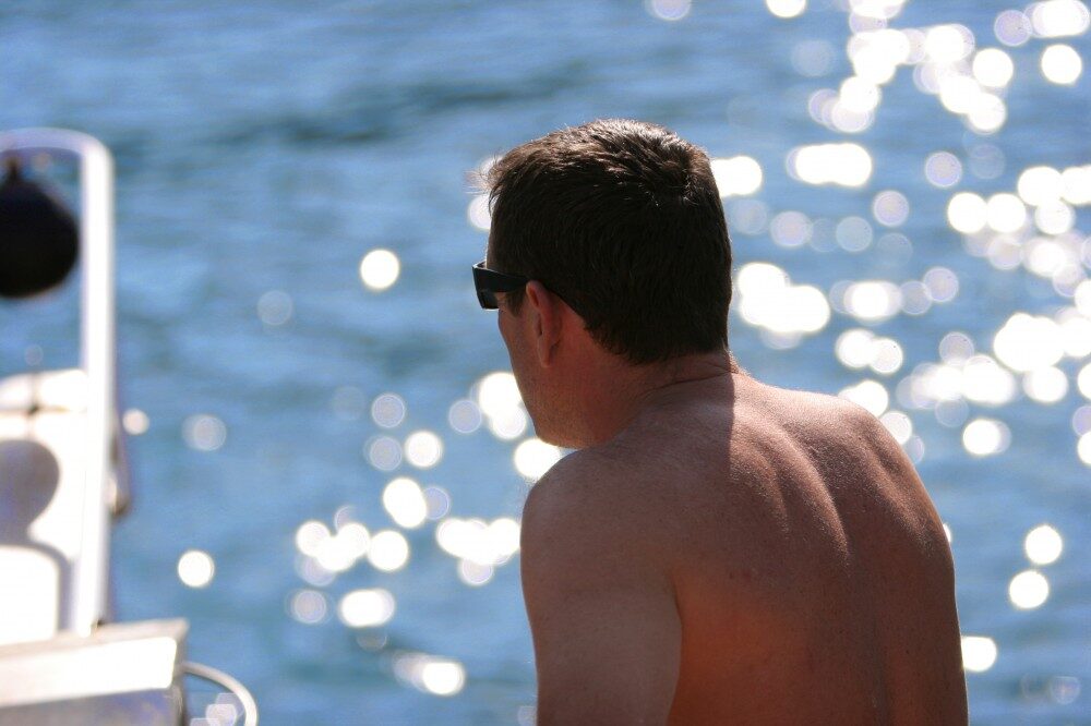 Foto: Muž sedící ma pláži